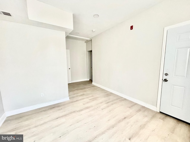 unfurnished room with baseboards, visible vents, and light wood-style floors