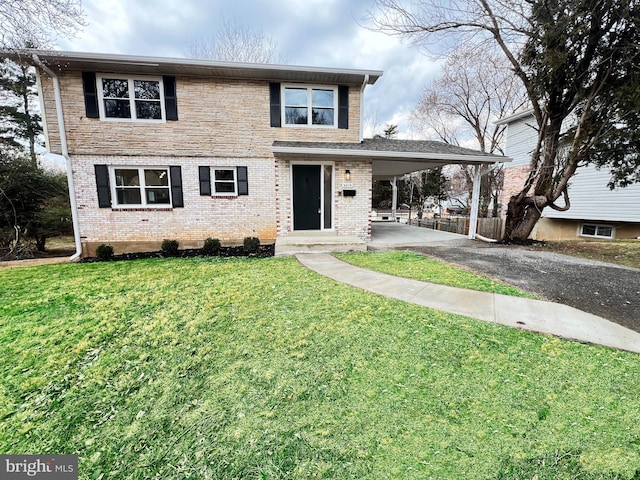 view of front of home featuring driveway, an attached carport, a front yard, and brick siding