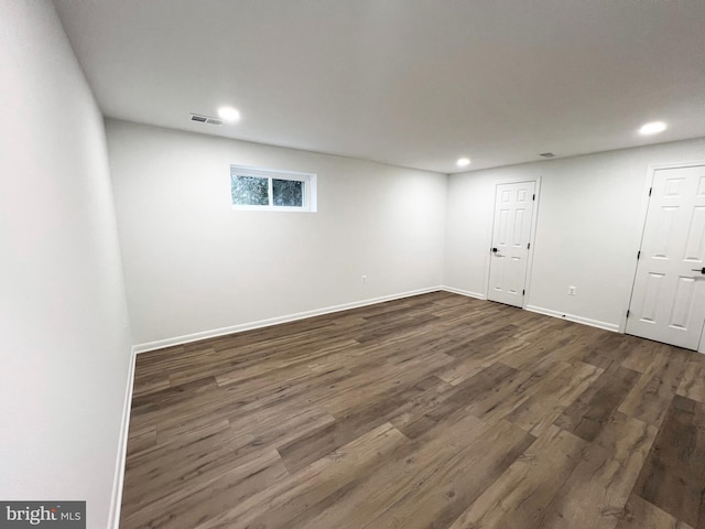 basement featuring recessed lighting, visible vents, dark wood finished floors, and baseboards