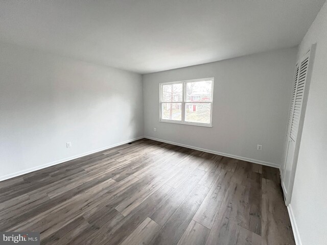 unfurnished bedroom featuring dark wood-style floors and baseboards