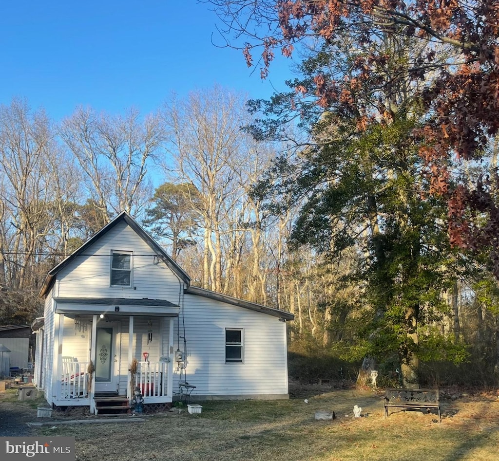 view of front of house featuring covered porch and a front yard