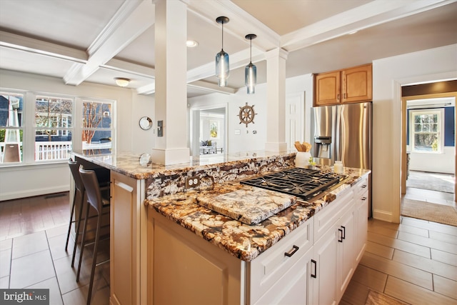 kitchen featuring coffered ceiling, a kitchen island, appliances with stainless steel finishes, beamed ceiling, and light stone countertops