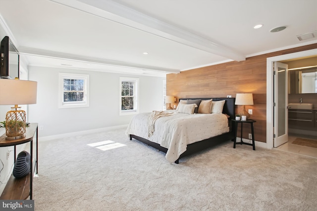 carpeted bedroom with wooden walls, visible vents, beam ceiling, crown molding, and a sink