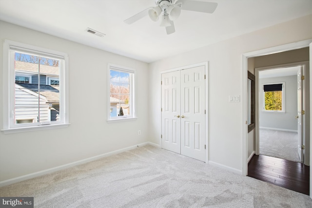 unfurnished bedroom featuring baseboards, a closet, visible vents, and carpet flooring