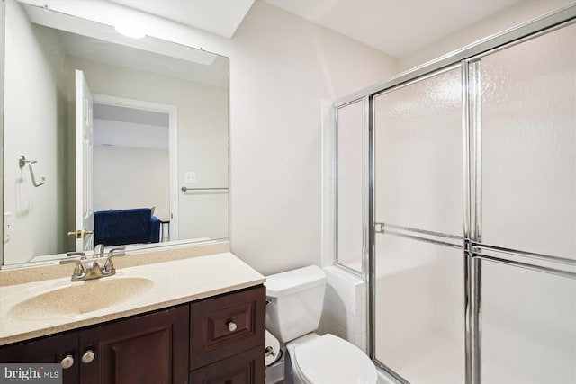 bathroom featuring toilet, a stall shower, and vanity