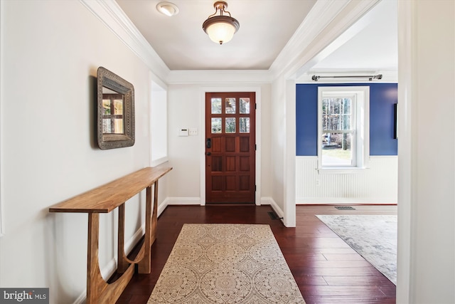 foyer entrance featuring ornamental molding, dark wood-style flooring, wainscoting, and visible vents