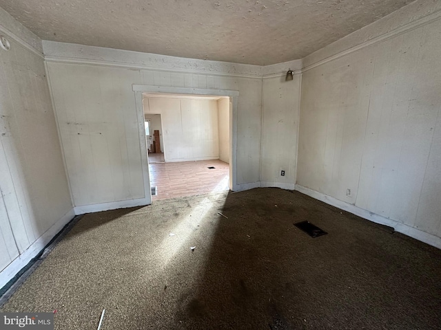 unfurnished room featuring baseboards and a textured ceiling