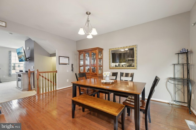 dining area with a notable chandelier, wood finished floors, visible vents, and baseboards