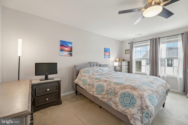 bedroom with light carpet, a ceiling fan, and baseboards