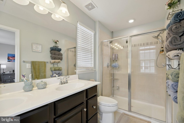 bathroom with a stall shower, visible vents, and a sink