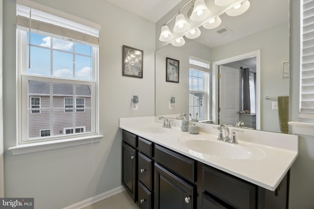 full bathroom with double vanity, a sink, visible vents, and baseboards