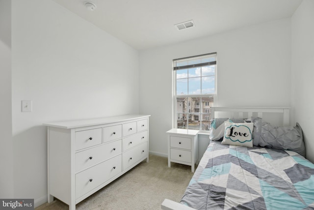 bedroom featuring light carpet, visible vents, and baseboards