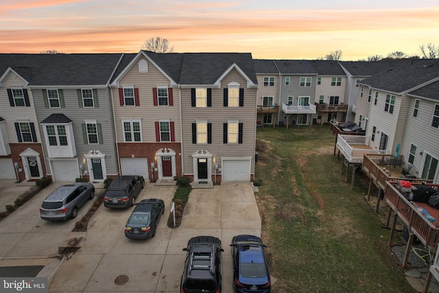 view of front facade featuring driveway, an attached garage, and a residential view