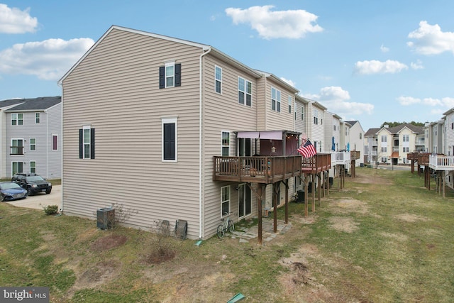 view of property exterior with a yard, central AC unit, a wooden deck, and a residential view