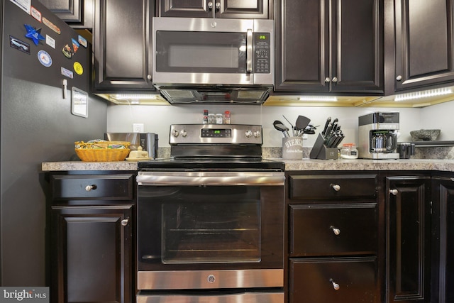 kitchen featuring appliances with stainless steel finishes, light countertops, and dark brown cabinets