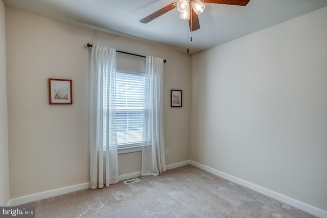 carpeted empty room with visible vents, ceiling fan, and baseboards