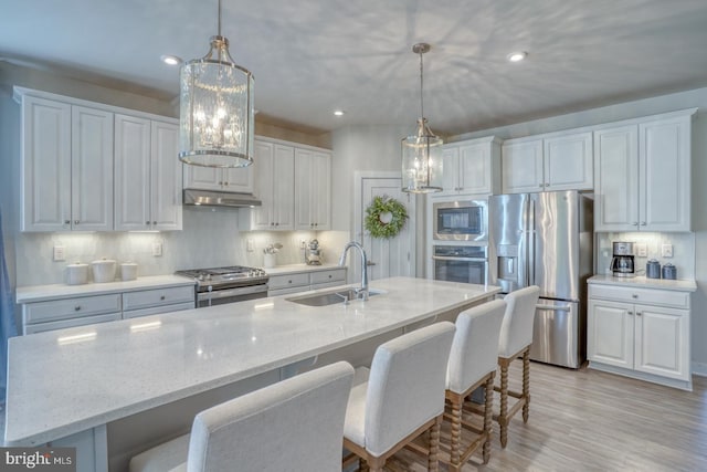 kitchen featuring white cabinetry, appliances with stainless steel finishes, decorative backsplash, and a sink