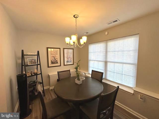 dining room with visible vents, baseboards, dark wood finished floors, and a notable chandelier