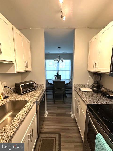 kitchen with dark wood-type flooring, a sink, white cabinets, and a toaster