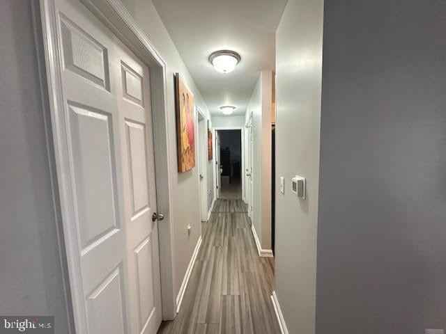 hall featuring wood finished floors and baseboards