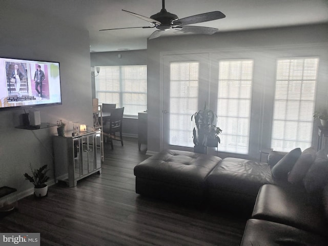 living room featuring a ceiling fan, baseboards, and wood finished floors