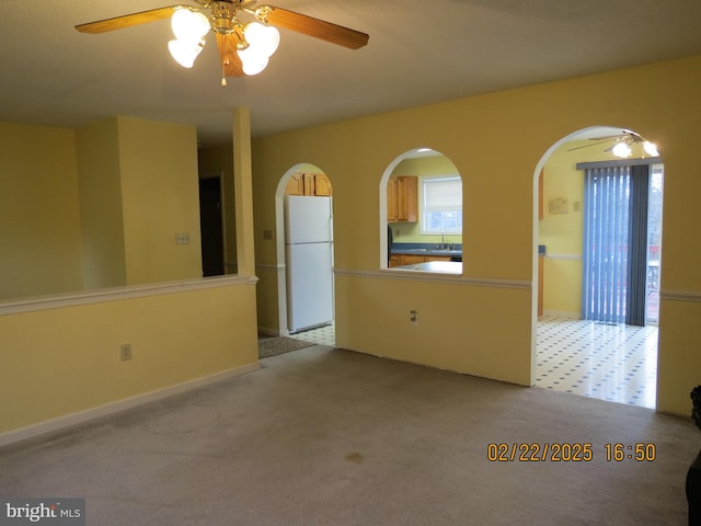 unfurnished room with carpet floors and a ceiling fan