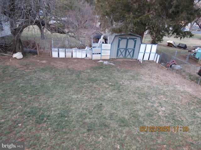 view of yard featuring an outdoor structure, fence, and a storage unit