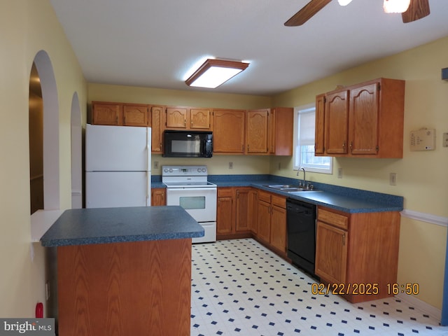 kitchen with a ceiling fan, dark countertops, a sink, and black appliances