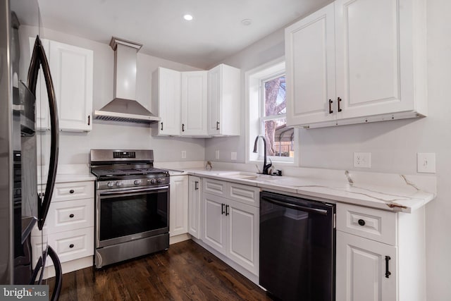 kitchen featuring a sink, wall chimney range hood, freestanding refrigerator, dishwasher, and stainless steel range with gas stovetop