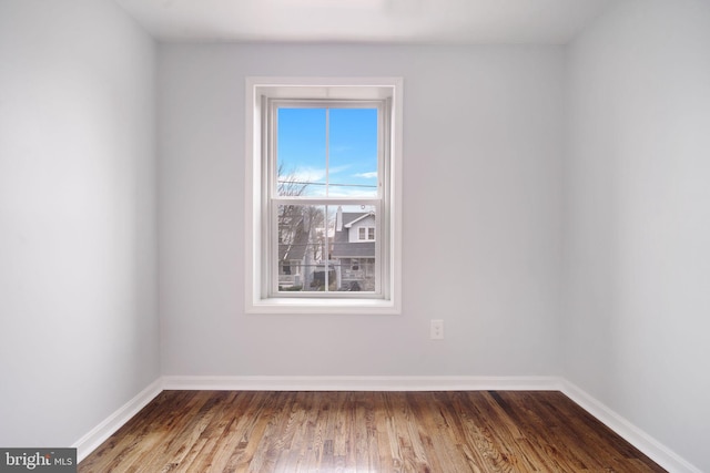 empty room with baseboards and wood finished floors