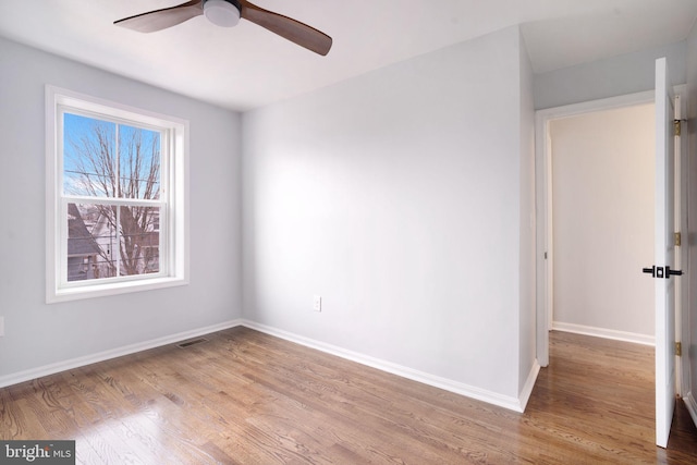 unfurnished room featuring visible vents, baseboards, ceiling fan, and wood finished floors