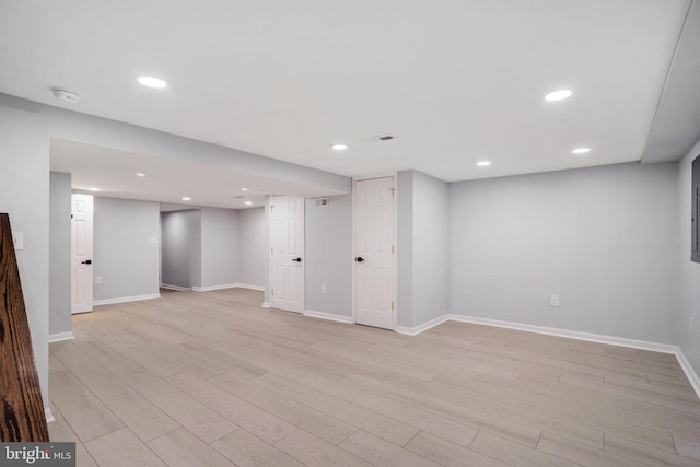 finished below grade area featuring light wood-style flooring, visible vents, baseboards, and recessed lighting