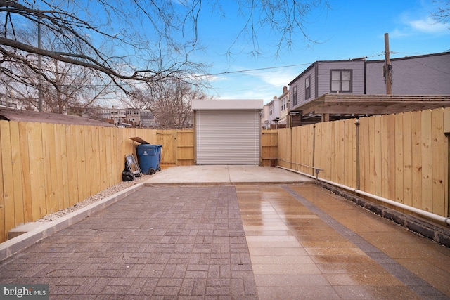 view of patio featuring an outbuilding, a storage shed, and a fenced backyard