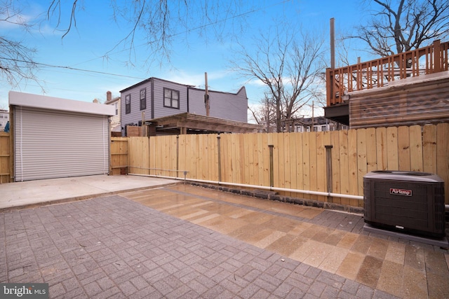 view of patio / terrace with central air condition unit, a shed, fence, and an outdoor structure