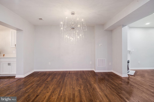 interior space with baseboards, visible vents, dark wood-style flooring, an inviting chandelier, and a fireplace