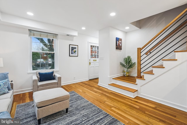 living area featuring wood-type flooring, stairway, baseboards, and recessed lighting