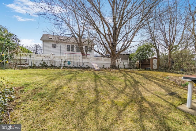 view of yard featuring a storage shed, an outbuilding, and a fenced backyard