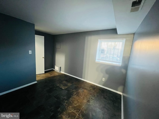 empty room with visible vents and baseboards