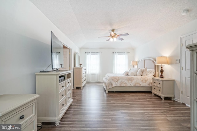 bedroom featuring a textured ceiling, dark wood-type flooring, lofted ceiling, and a ceiling fan