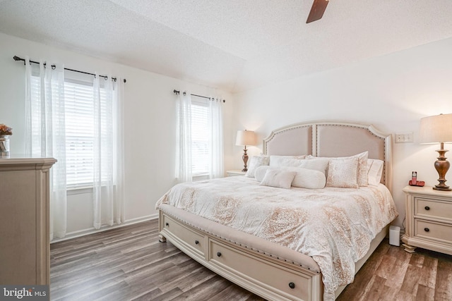 bedroom featuring lofted ceiling, multiple windows, and wood finished floors