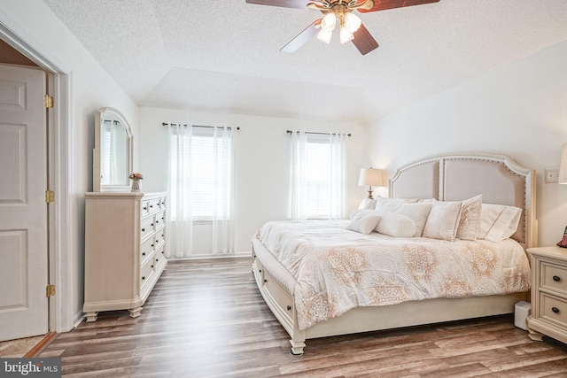 bedroom with light wood finished floors, ceiling fan, and a textured ceiling