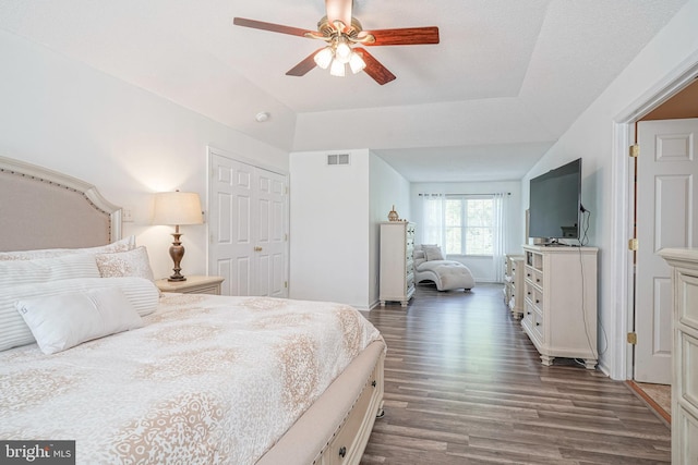 bedroom featuring a ceiling fan, dark wood-style flooring, visible vents, and a closet