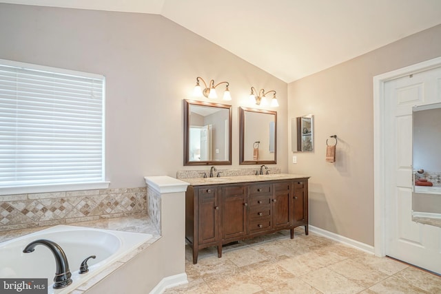 full bathroom featuring lofted ceiling, a sink, baseboards, a bath, and double vanity