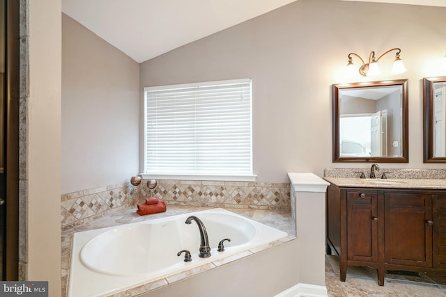 full bathroom featuring a garden tub, vaulted ceiling, and vanity