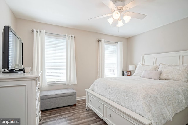 bedroom with multiple windows, ceiling fan, baseboards, and wood finished floors