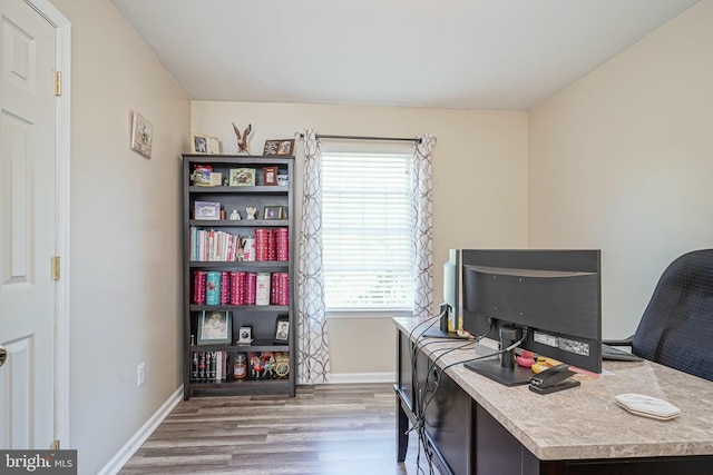 home office with baseboards and wood finished floors