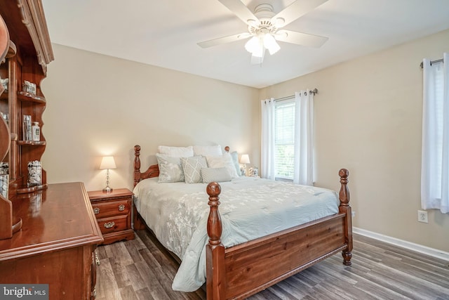 bedroom with wood finished floors, a ceiling fan, and baseboards