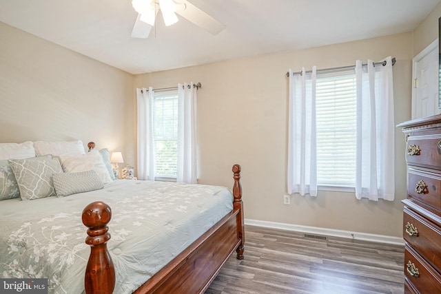 bedroom featuring dark wood-style flooring, ceiling fan, and baseboards