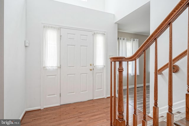 entryway featuring baseboards, stairway, and wood finished floors