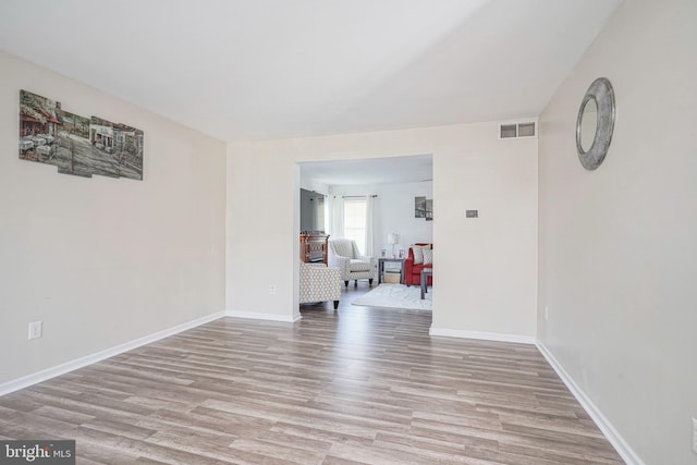 empty room with light wood-type flooring, baseboards, and visible vents